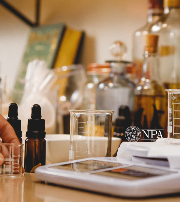 A gold embossed book, perfumers scales and bottles of essential oils on a workbench