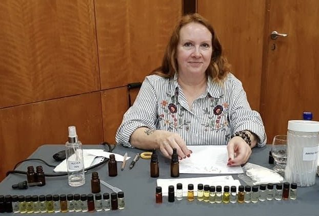 Justine Crane teaching natural perfumery at a desk, sharing her knowledge as a co-founder of the Natural Perfume Academy.