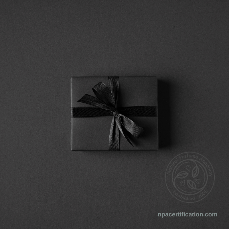 a luxury gift box, wrapped in black paper with a black satin background