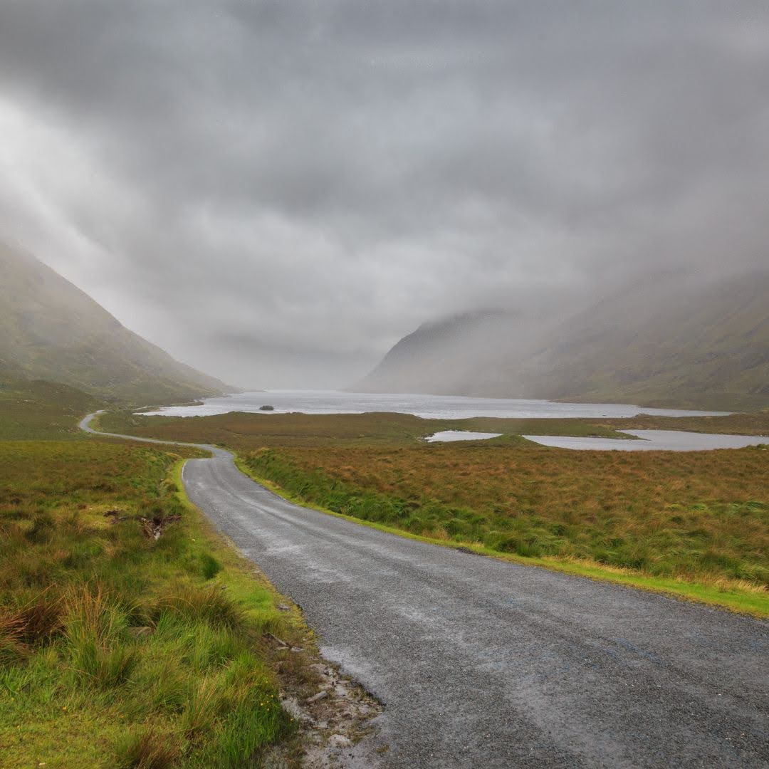 Misty Irish landscape with winding country road and lake, reflecting the natural origins and journey of botanical perfumeryNatural perfumery begins in places like this.
